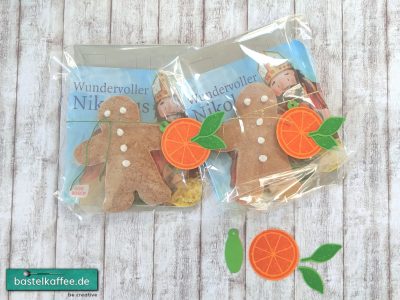 Nikolausgeschenk für Kinder. Pixi-Buch vom Nikolaus und Lebkuchenmännchen verpackt in einer transparenten Tüte. Dekoriert mit einer gestempelten und ausgestanzten Orangenscheibe.